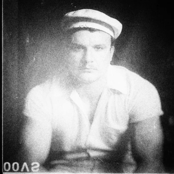 Possible image of DJ Southworth.Black and white photo of a person wearing a cap and a light-colored shirt.
